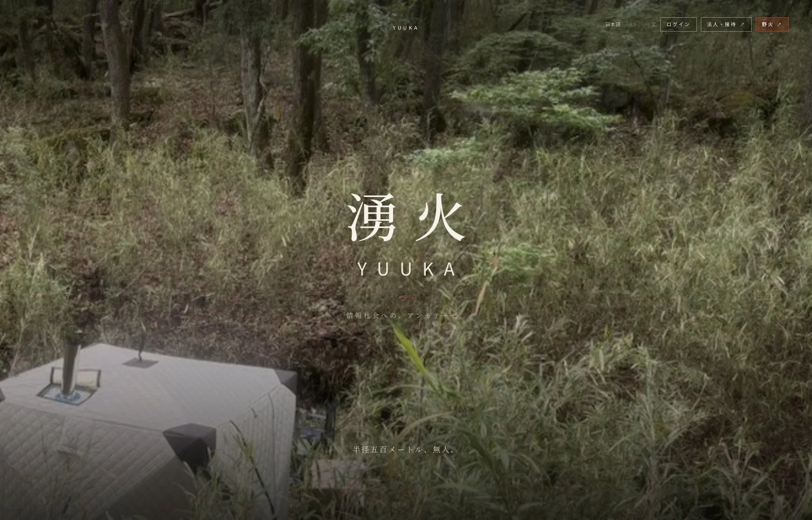 緑豊かな森の中に、白いサウナのようなテントが設置されている。中央には「湧火 YUUKA」の文字があり、情報社会からの静かな逃避や自然との一体感を表現している。