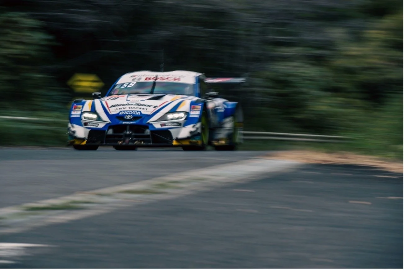 青と白のトヨタ スープラ GTカーが走行する様子