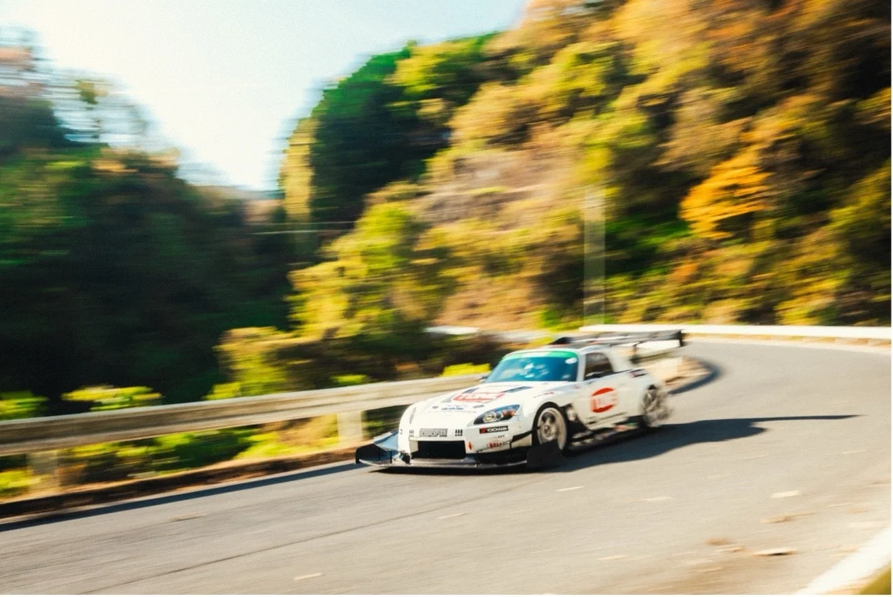 白いホンダS2000が山道をコーナリングする様子